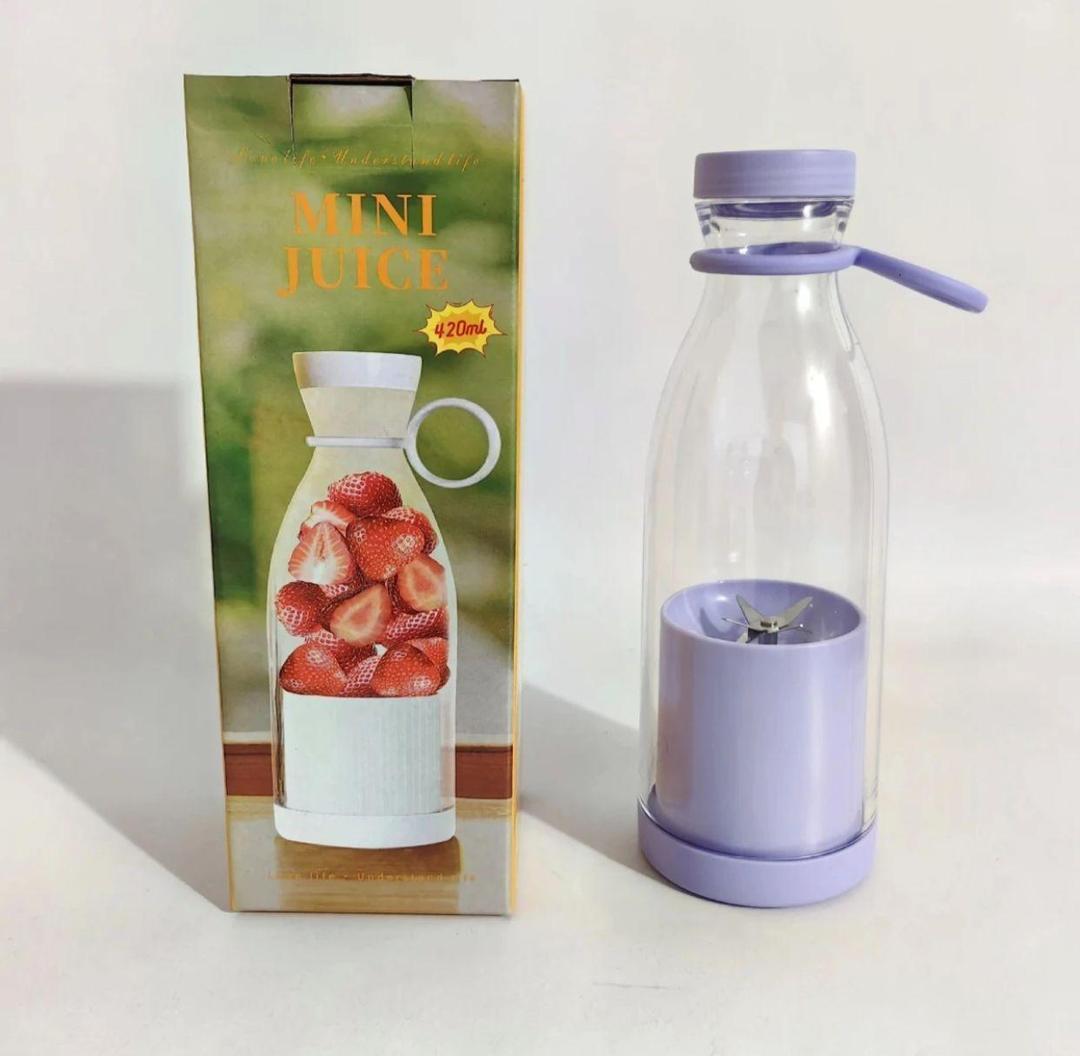 Mini juice maker with packaging on a white background