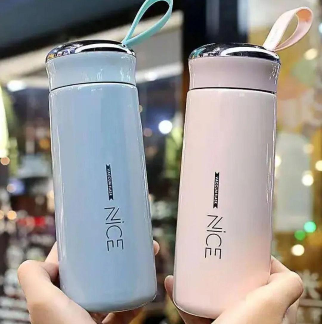 Two gradient water bottles, one blue and one pink, held by a hand on a white background.