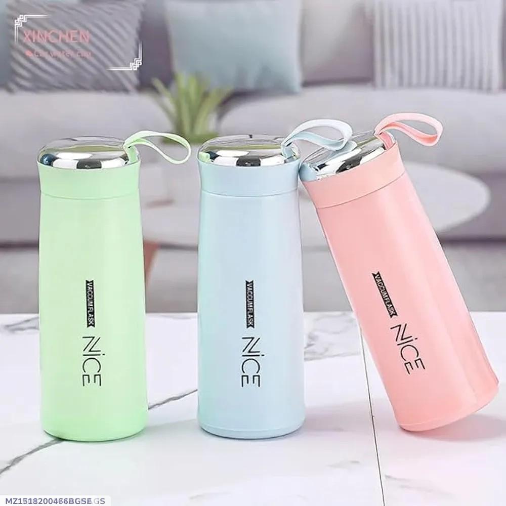 Three insulated cups in green, blue, and pink on a light surface with a blurred background.